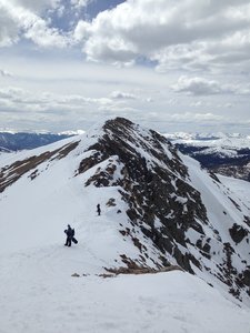 Looking back across the ridge from near the North Pole entrance, with two skiers standing at the Narrow North Pole entrance and Little Lenawee Peak in the distance.