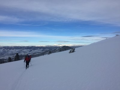 A pair of skiers ascends high up on New York Mountain.
