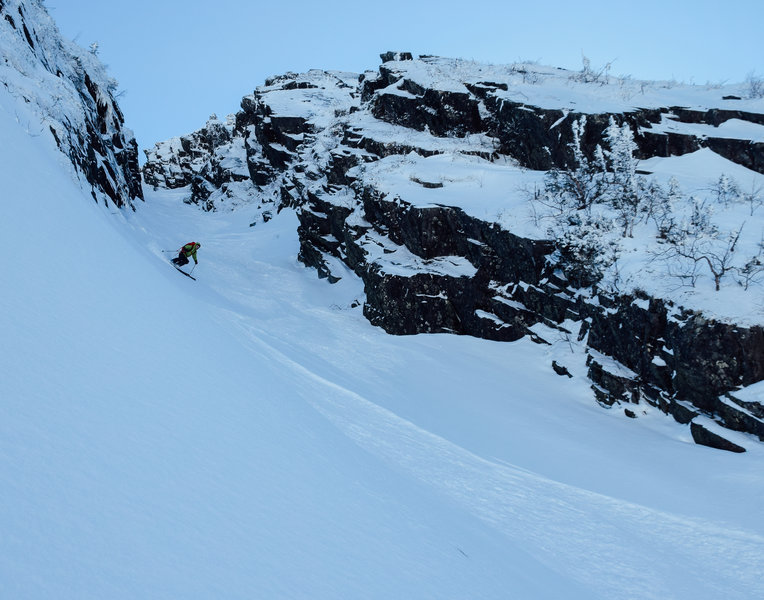 A skier carves through the bottom of the Couloir des Légend.