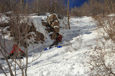 @_yourmyboyblue looks on as @rayrose9990 navigates an icy bed surface in the Snowshoe Couloir, after much of the chute sluffed out