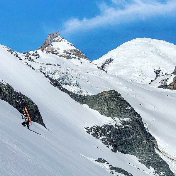 Vik Sahney ascending an icy steep section enroute to Little Tahoma; Mt. Rainier looms in the background (Photo Credit - Gavin Woody)