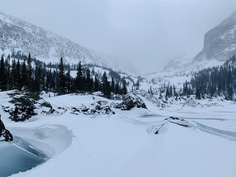 Standing on Lake Haiyaha, hippy trees can be seen to the left and back.