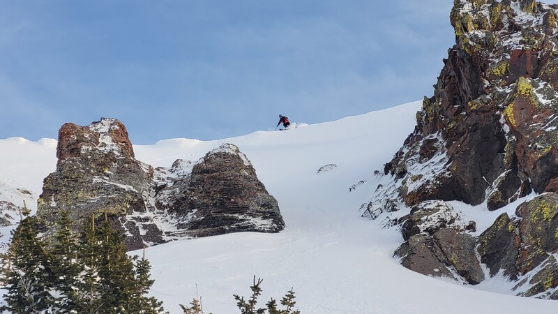 Looking up the left chute of Hourglass (looker's right). Skier dropping into the middle of the upper bowl.